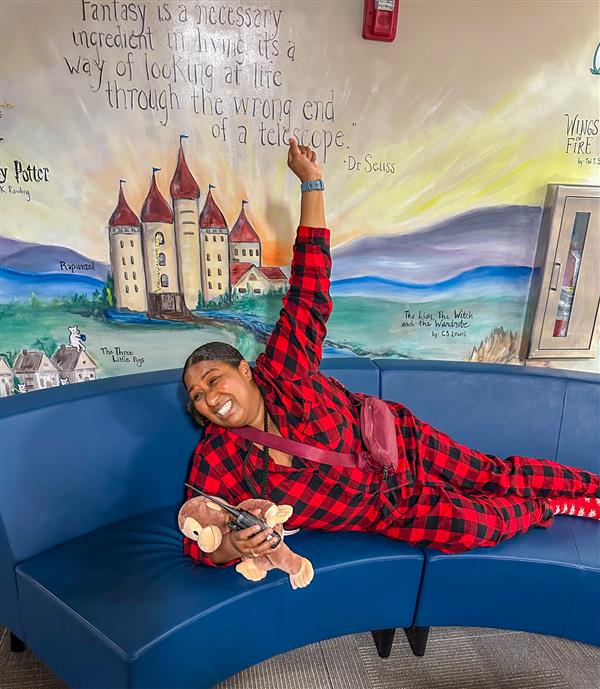 principal posing with monkey stuffed animal posing on couch